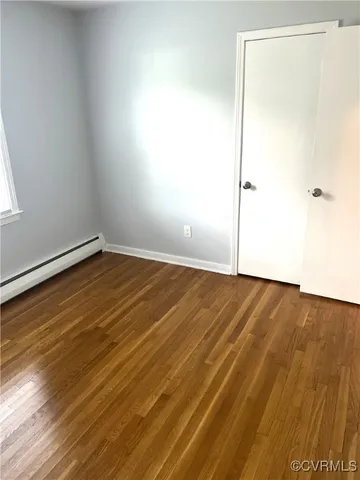 a view of an empty room with wooden floor