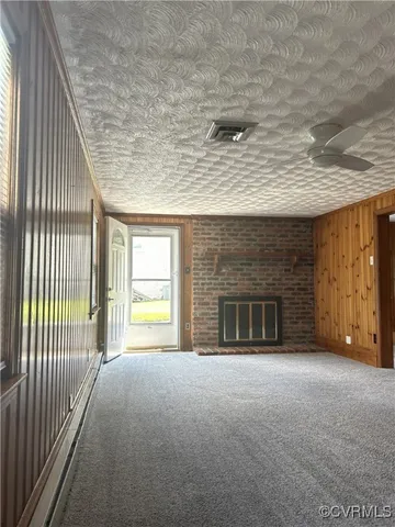 a view of an empty room with a fireplace and a window