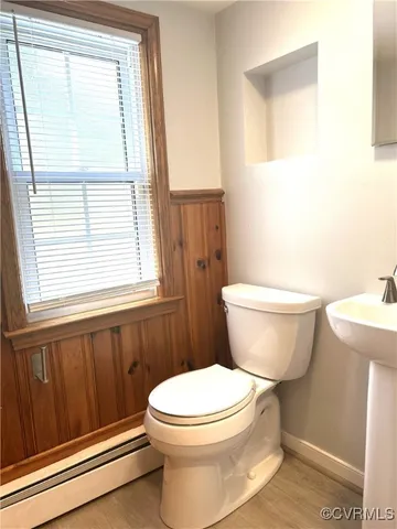 a bathroom with a toilet a sink and a window