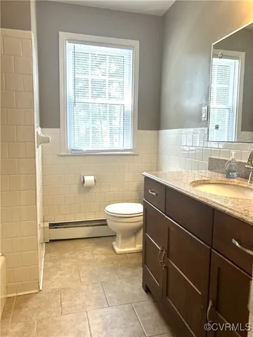 a bathroom with a granite countertop toilet a sink and a mirror
