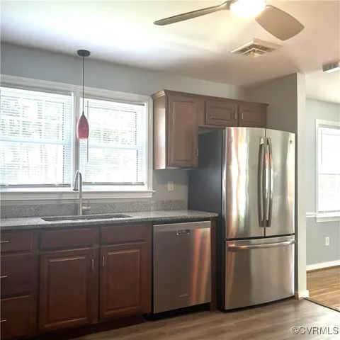 a kitchen with kitchen island granite countertop a sink window and refrigerator