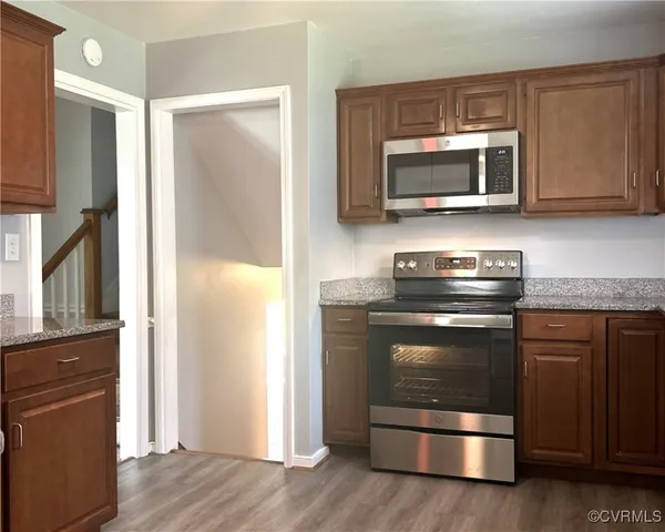 a kitchen with granite countertop a stove and a microwave