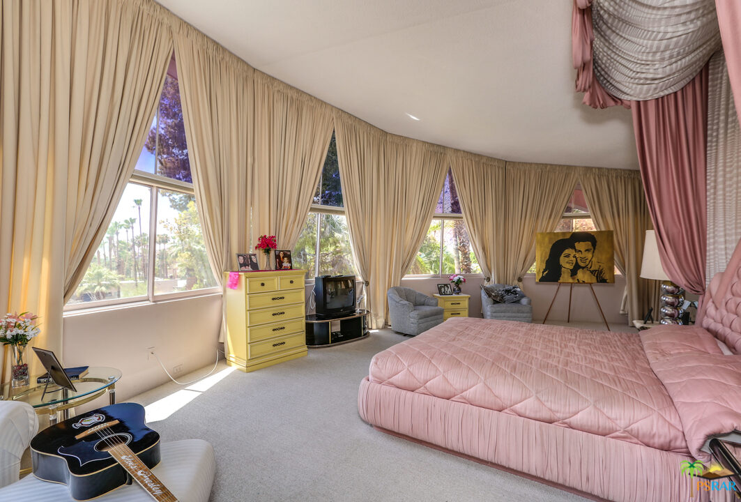 1350 Ladera Circle Palm Springs, CA 92262 - Photo 37 of 50 a bedroom with a bed and a chandelier