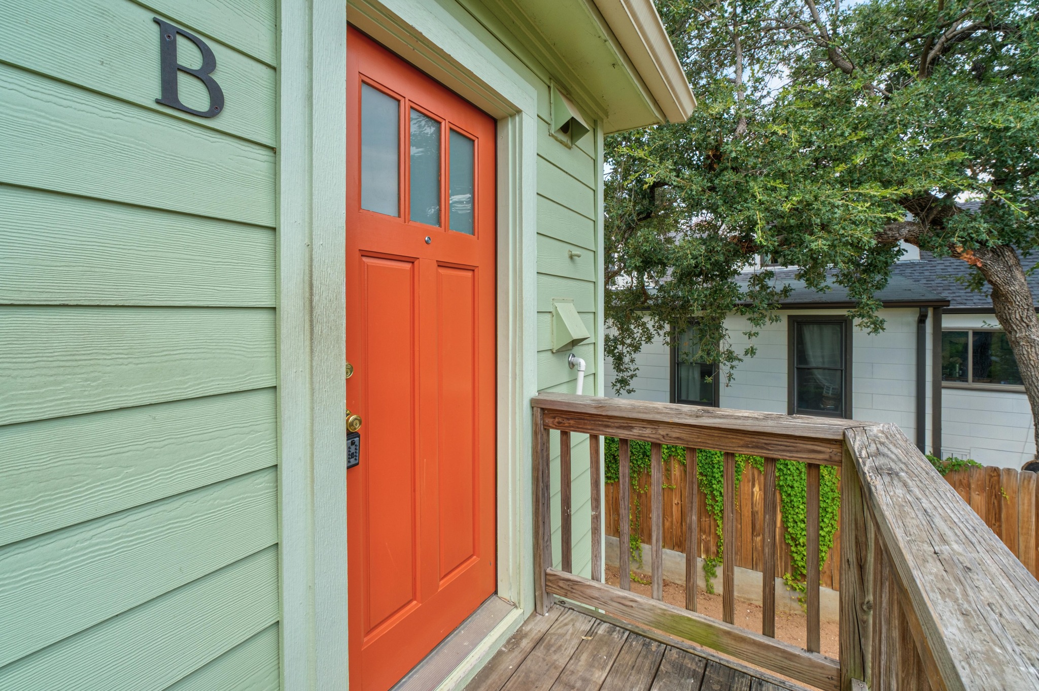 2012 Enfield Road, Unit B Austin, TX 78703 - Photo 2 of 20 A vibrant entry door welcomes guests, complemented by durable hardiplank siding and a natural wood railing.