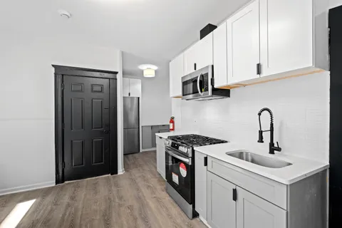 a kitchen with stainless steel appliances granite countertop a sink and a stove