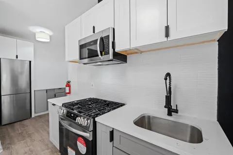 a kitchen with stainless steel appliances granite countertop a sink stove and microwave