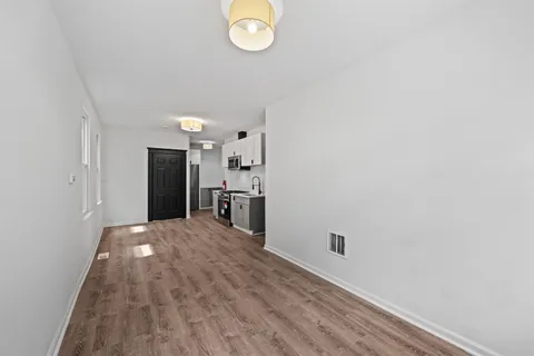 a view of empty room with wooden floor