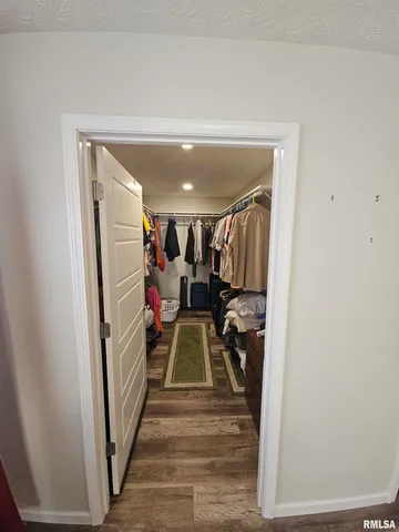 a view of a hallway with wooden floor and stairs