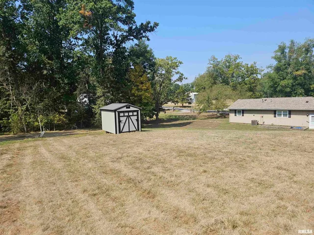 a view of a house with backyard and trees