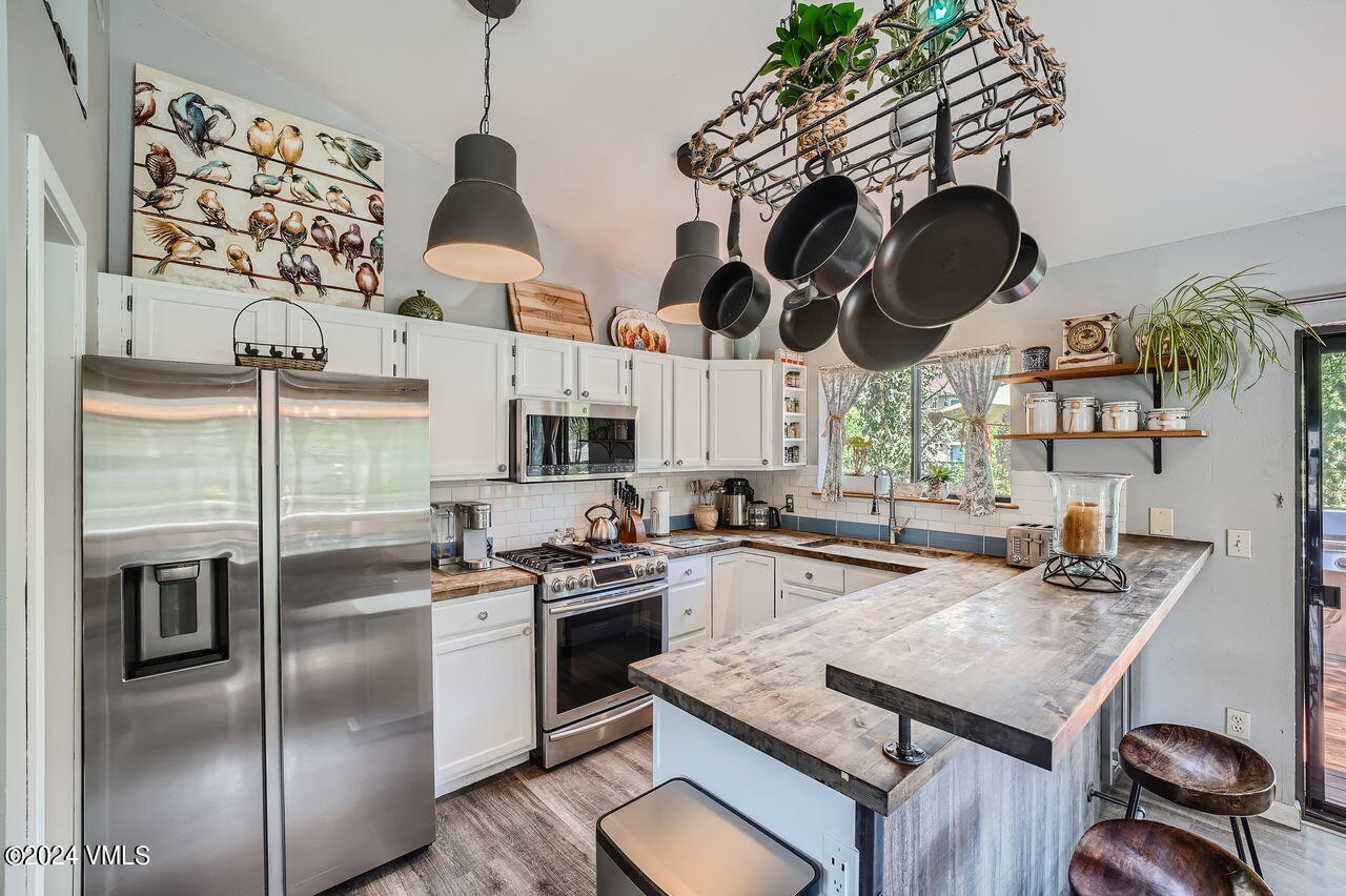 316 Golden Eagle Eagle, CO 81631 - Photo 10 of 25 a kitchen with stainless steel appliances granite countertop a stove a sink dishwasher and a refrigerator with wooden floor