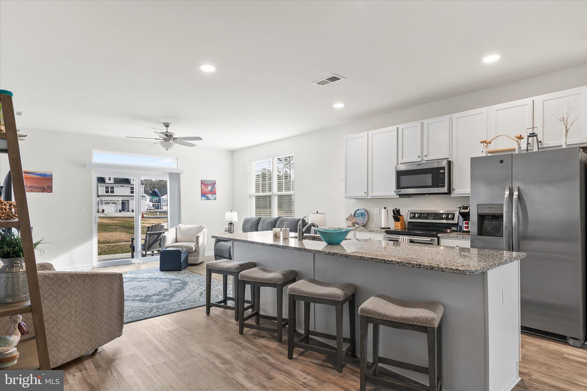 33204 Cross Road Frankford, DE 19945 - Photo 7 of 35 a large kitchen with kitchen island a dining table chairs stainless steel appliances and cabinets