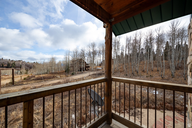 2029 West Tollgate Road Coalville, UT 84017 - Photo 18 of 36 Covered deck featuring wood posts, a wood railing with metal balusters, and a green metal roof