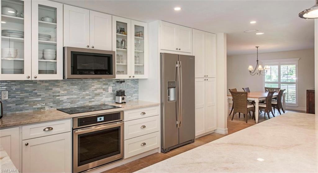 508 Devils Lane Naples, FL 34103 - Photo 7 of 15 a kitchen with stainless steel appliances granite countertop a stove microwave and refrigerator