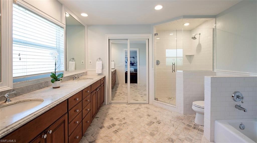 508 Devils Lane Naples, FL 34103 - Photo 9 of 15 a bathroom with a granite countertop sink a toilet a tub and shower