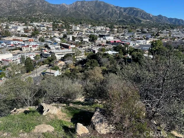 an aerial view of a houses with a lush green hillside