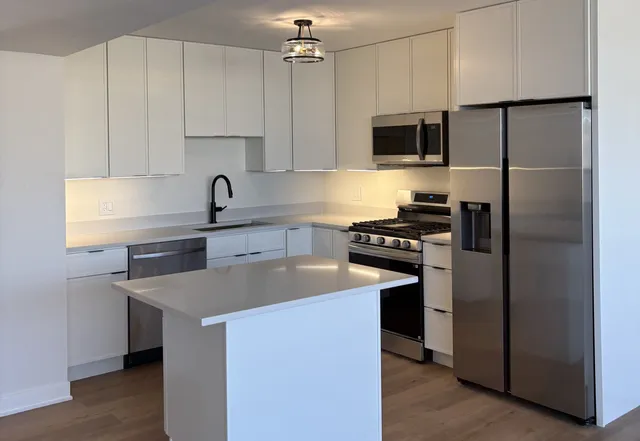 a kitchen with a sink stainless steel appliances and cabinets