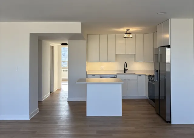 a kitchen with a refrigerator sink and cabinets