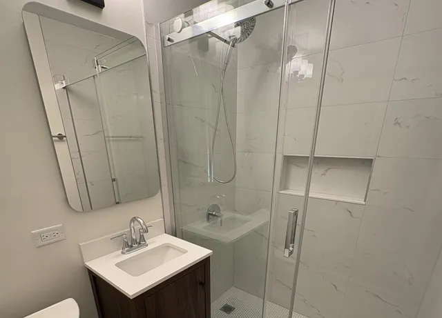 a bathroom with a sink a mirror and shower
