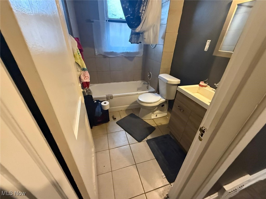 869 Whitcomb Road Cleveland, OH 44110 - Photo 7 of 8 Full bathroom featuring tile patterned flooring, toilet, vanity, and shower / tub combo with curtain