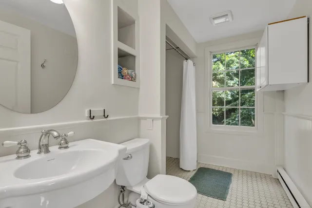 a bathroom with a granite countertop toilet and a sink