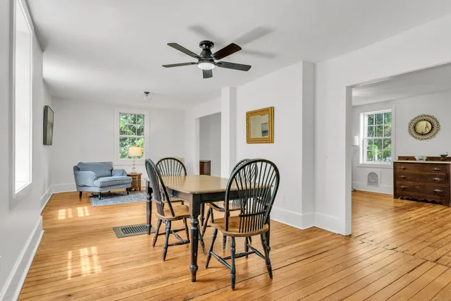 a view of a a dining room with furniture window and wooden floor