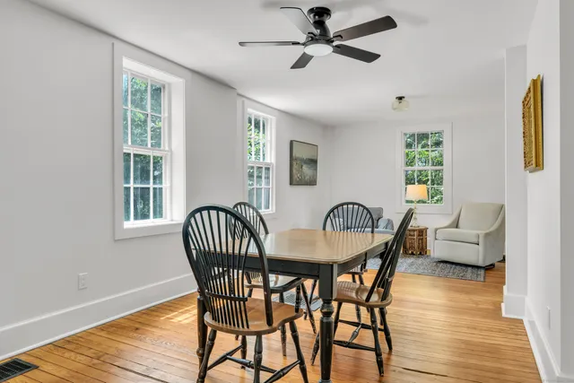a dining room with furniture a chandelier and wooden floor