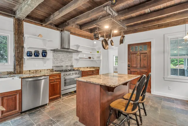 a open kitchen with stainless steel appliances granite countertop a stove and a refrigerator