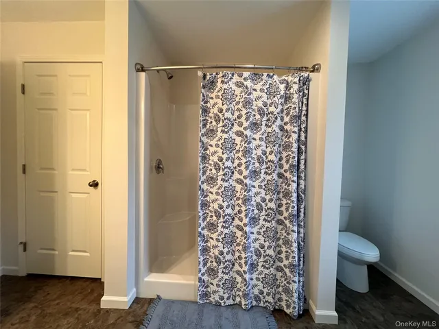 a bathroom with a toilet and a shower curtain