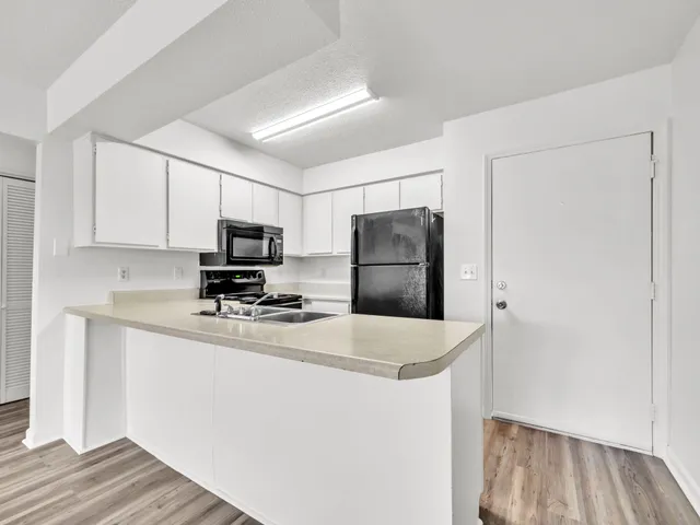 a kitchen with refrigerator and microwave