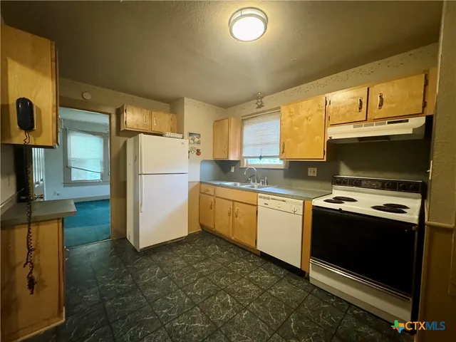 a kitchen with a refrigerator sink and stove top oven
