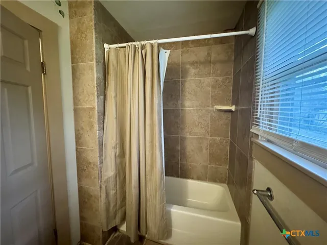 a bathroom with a shower and a tub