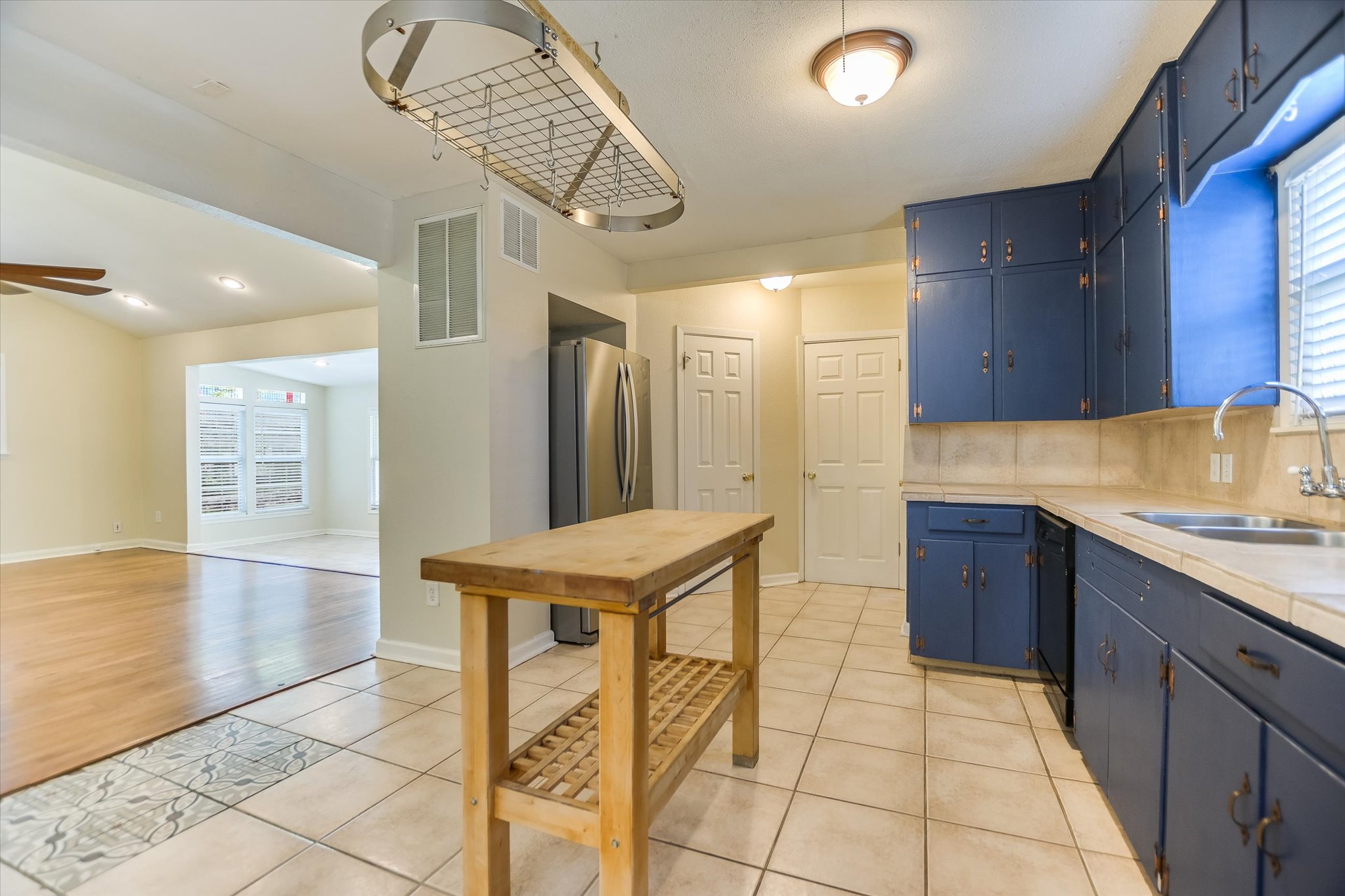 208 Braeswood Road Austin, TX 78704 - Photo 7 of 20 A functional kitchen boasts ample cabinetry and a portable island, connecting seamlessly to a bright living area.