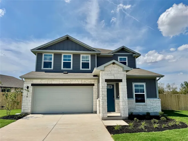 a front view of a house with yard and garage