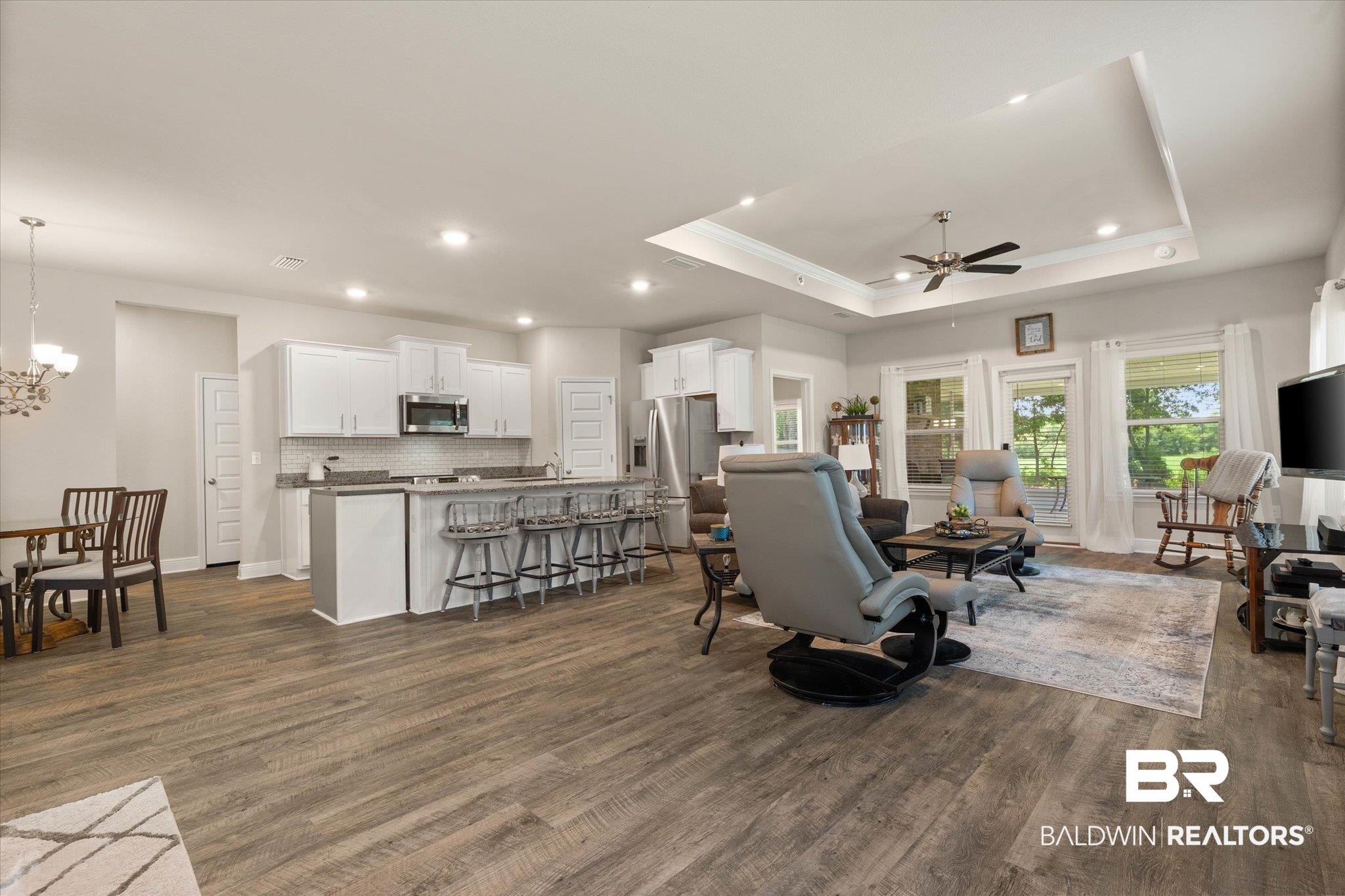 9037 Impala Drive Foley, AL 36535 - Photo 17 of 21 Living room featuring a tray ceiling, dark wood finished floors, ceiling fan, ornamental molding, and recessed lighting