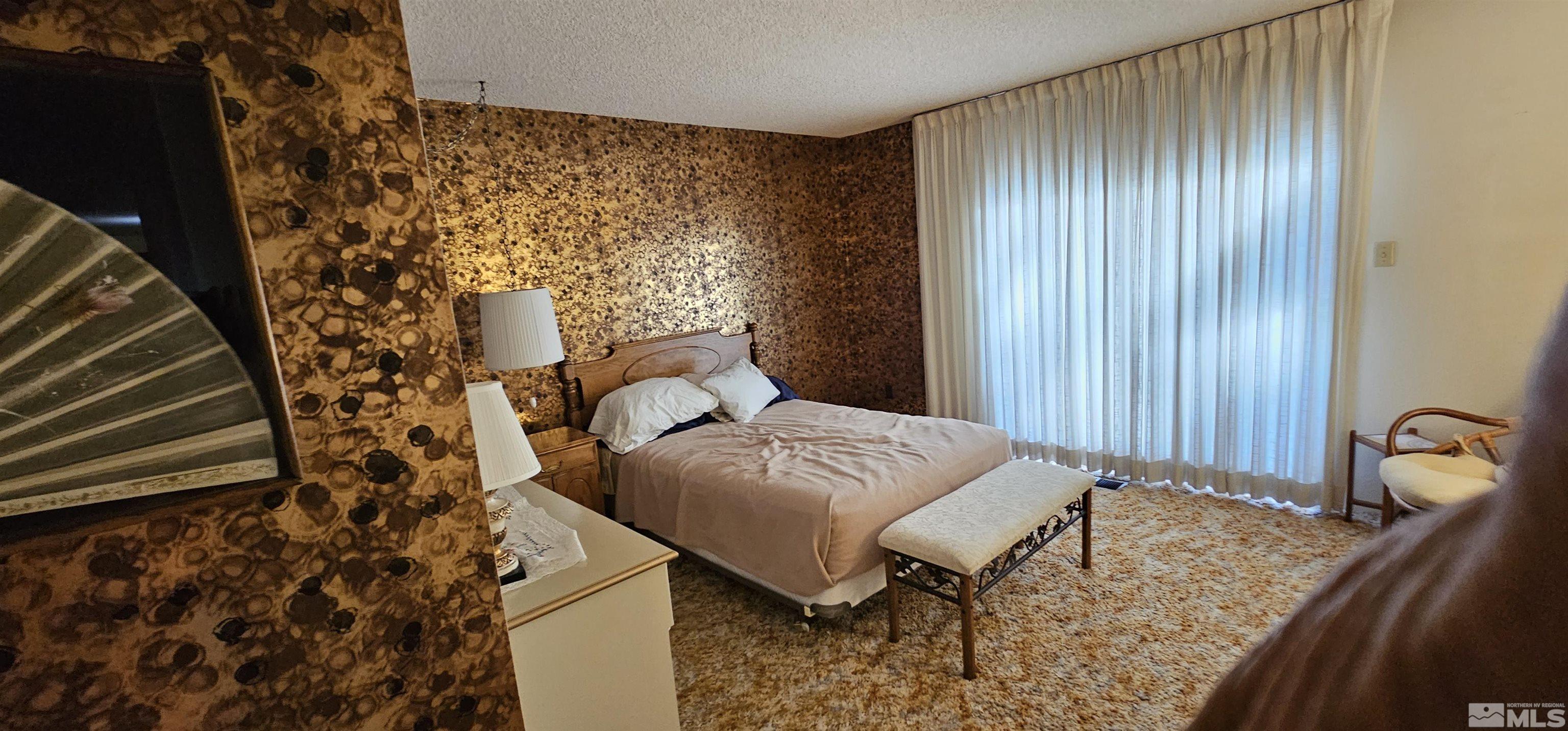 1475 Joshua Drive Reno, NV 89509 - Photo 14 of 27 a bedroom with a bed and a chair