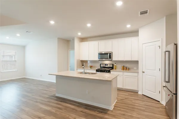 a bedroom with a large bed and a flat tv screen on dresser