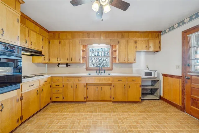 a large kitchen with stainless steel appliances granite countertop a refrigerator a sink dishwasher a stove with a dining table and chairs