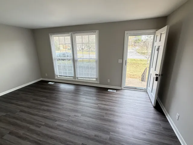 a kitchen with granite countertop a refrigerator a sink a stove and white cabinets