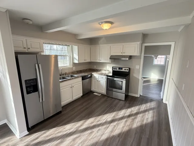 a kitchen with stainless steel appliances a refrigerator sink and cabinets