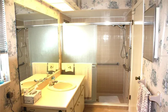 a bathroom with a granite countertop shower sink and mirror