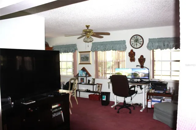 a view of a workspace with furniture and a window