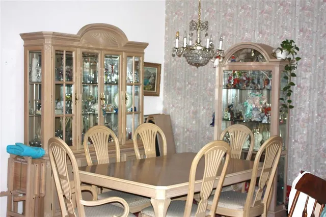a view of a dining room with furniture a chandelier and wooden floor