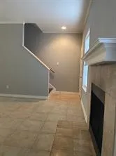 a view of empty room with wooden floor and fireplace