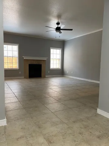 a view of an empty room with a fireplace and a window