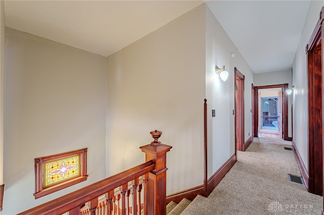 308 Yankee Road Middletown, OH 45044 - Photo 24 of 47 This interior showcases a classic wooden staircase with a beautiful stained-glass window accent.