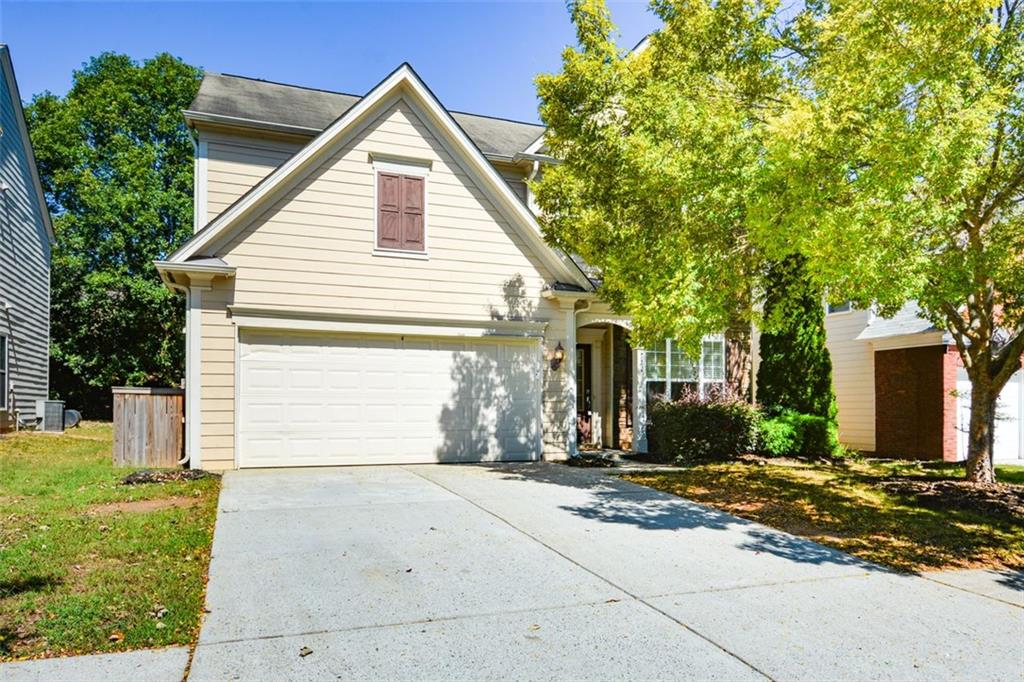 a view of a house with a yard and large tree