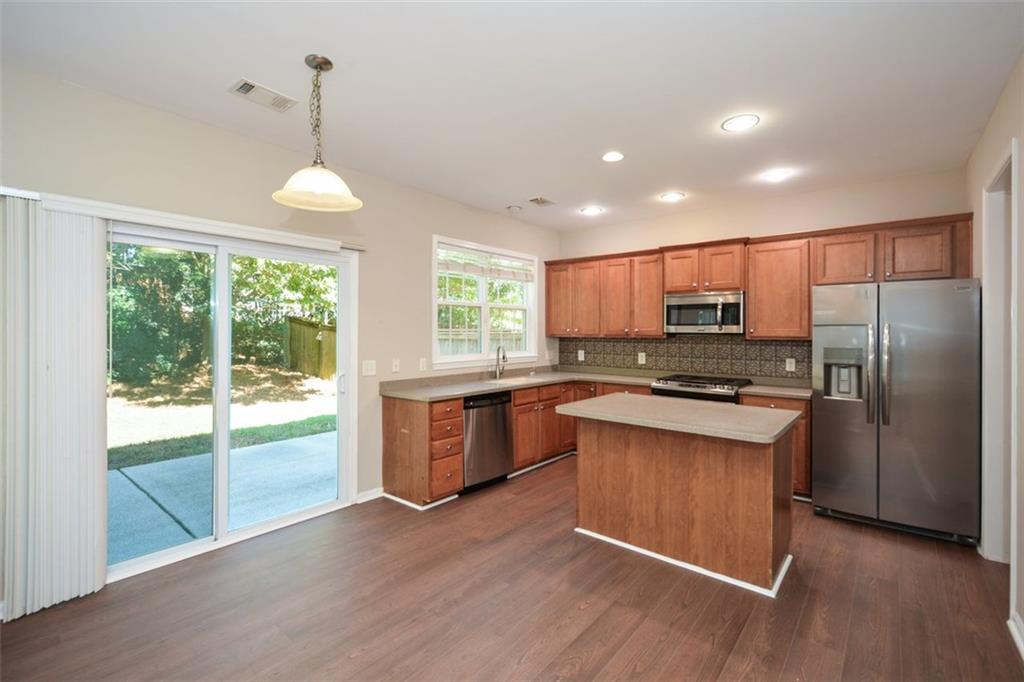 710 Berkeley Terrace Canton, GA 30115 - Photo 13 of 49 a kitchen with stainless steel appliances granite countertop a refrigerator a sink dishwasher a stove and white countertops with wooden floor