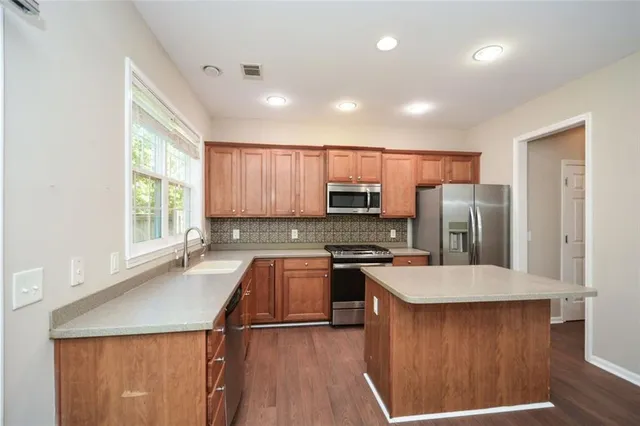 a large kitchen with a large window in it and stainless steel appliances