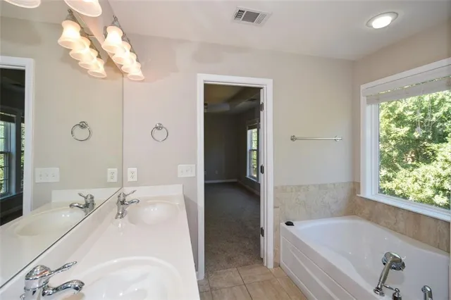 a bathroom with a tub sink and mirror