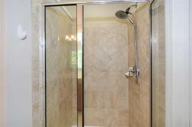 a bathroom with a glass shower door and mirror